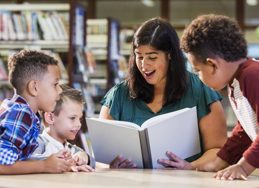 Lady reading a book to children